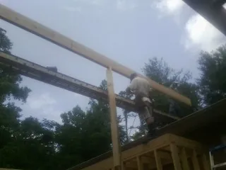 Carpenter setting a ridge beam over a new addition frame — Ice Dam Removal by Roofing Brothers in Baldwyn