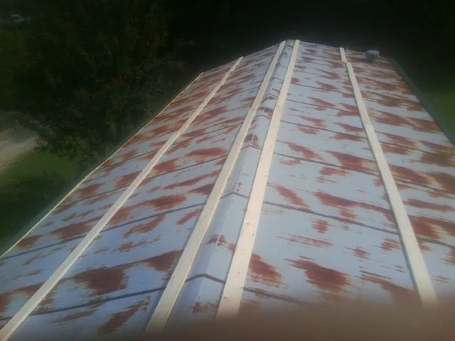 Rusted metal roof panels with new wood purlins before replacement — Storm Damage Roof Repair in Baldwyn by Roofing Brothers